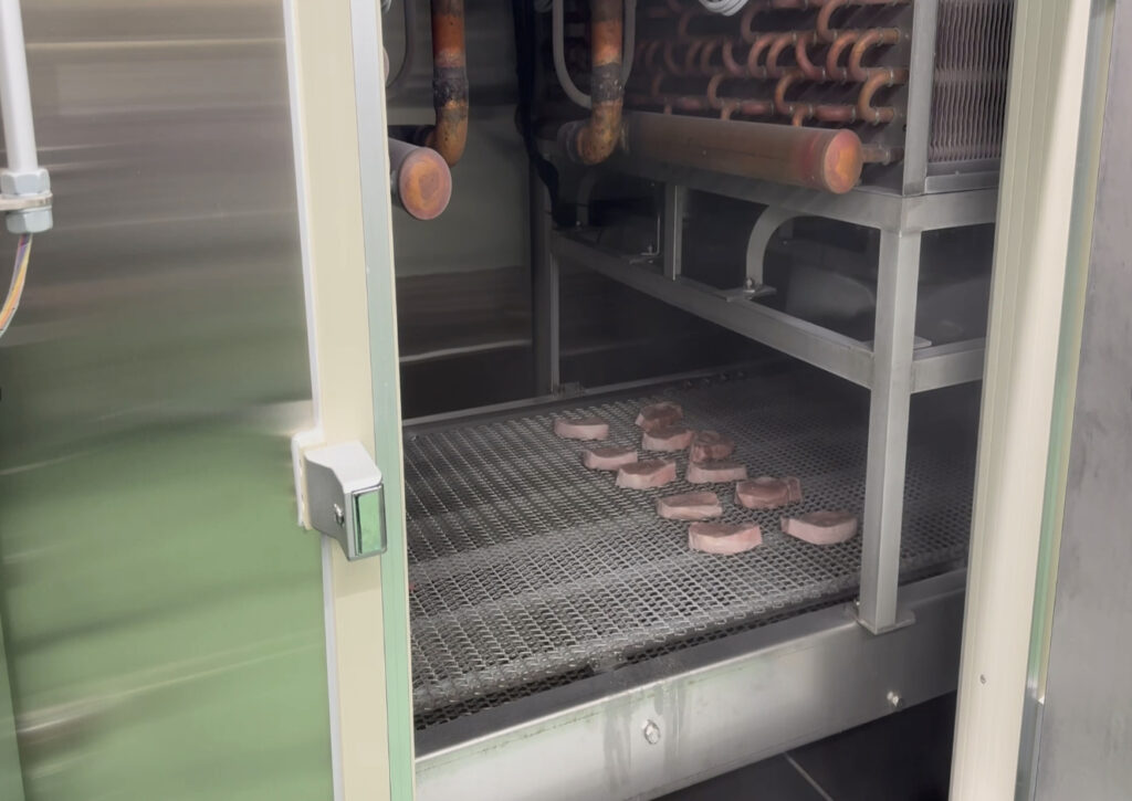 トンネルフリートンネルフリーザーのベルト上に製品が流れているザーのベルト上に製品が流れている