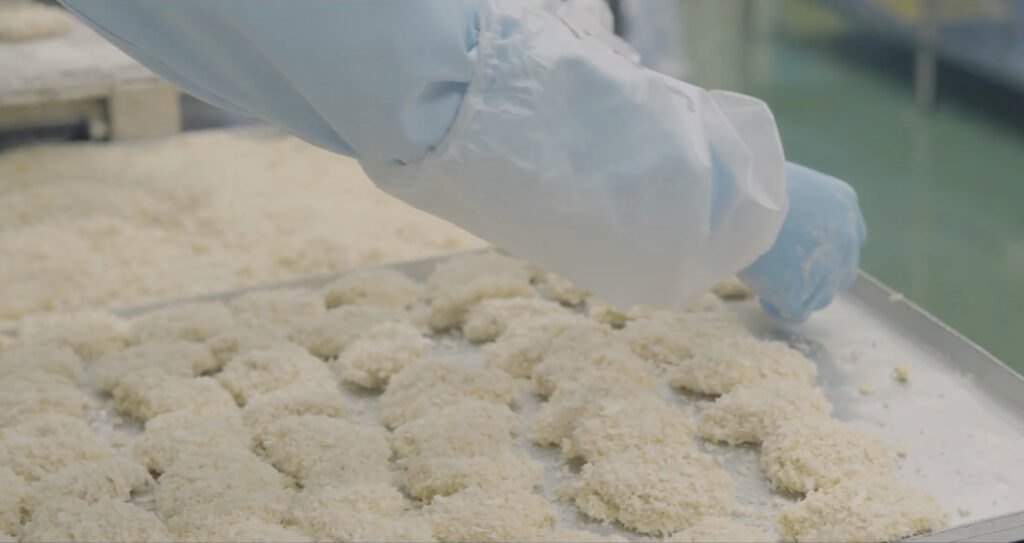 パン粉つき製品をトレーに並べている様子